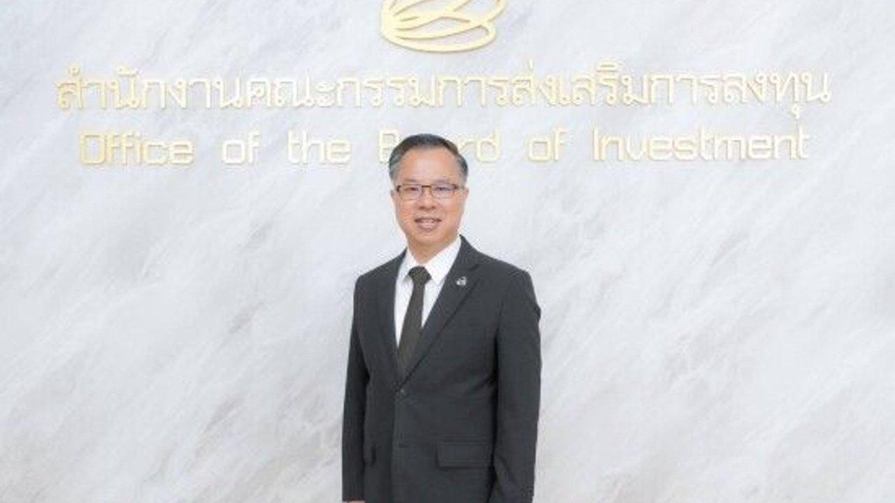 Mr Narit Therdsteerasukdi in a black suit standing before an Office of the Board of Investment sign.