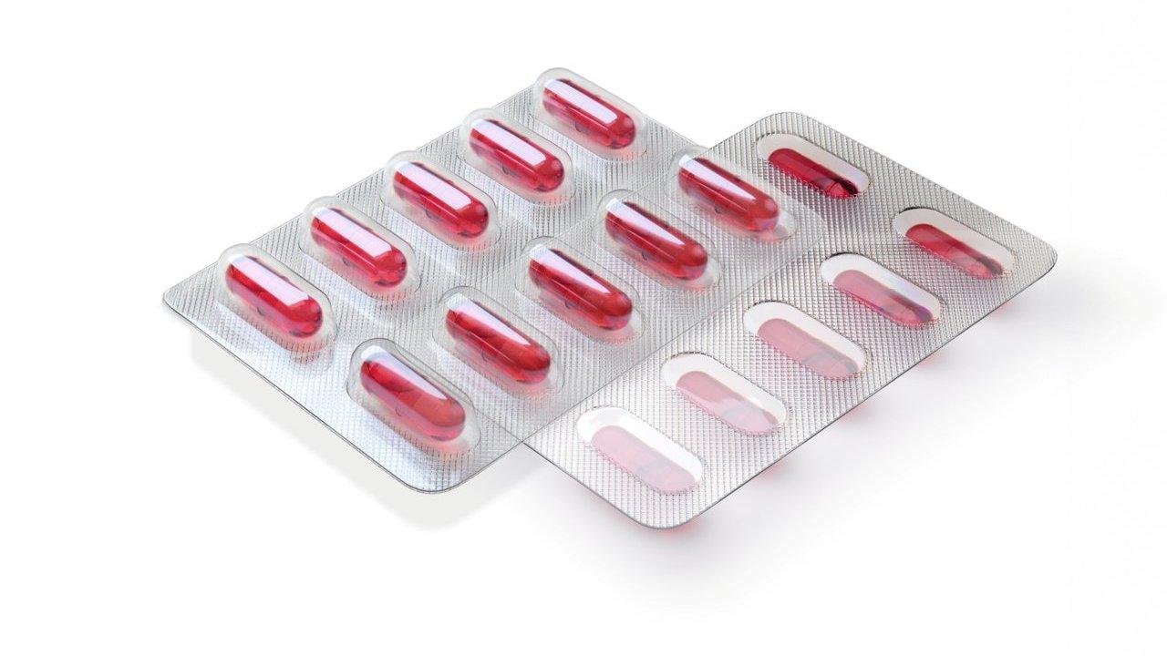 Two overlapping blister packs of red capsules on a white background.