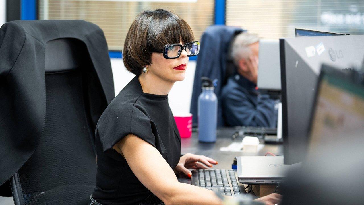 Designer wearing glasses working at a computer in an office.