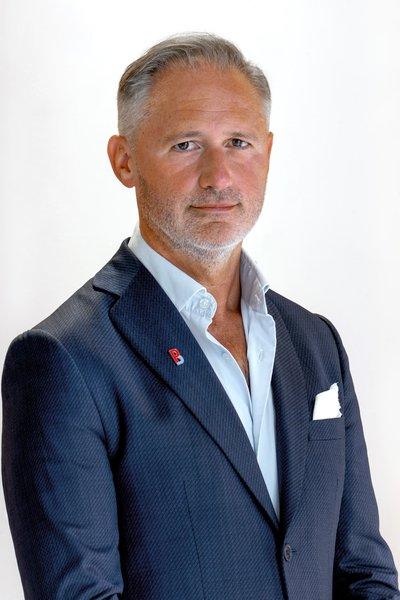 Ivan Jimenez Aira in a navy suit jacket and white shirt against a white background