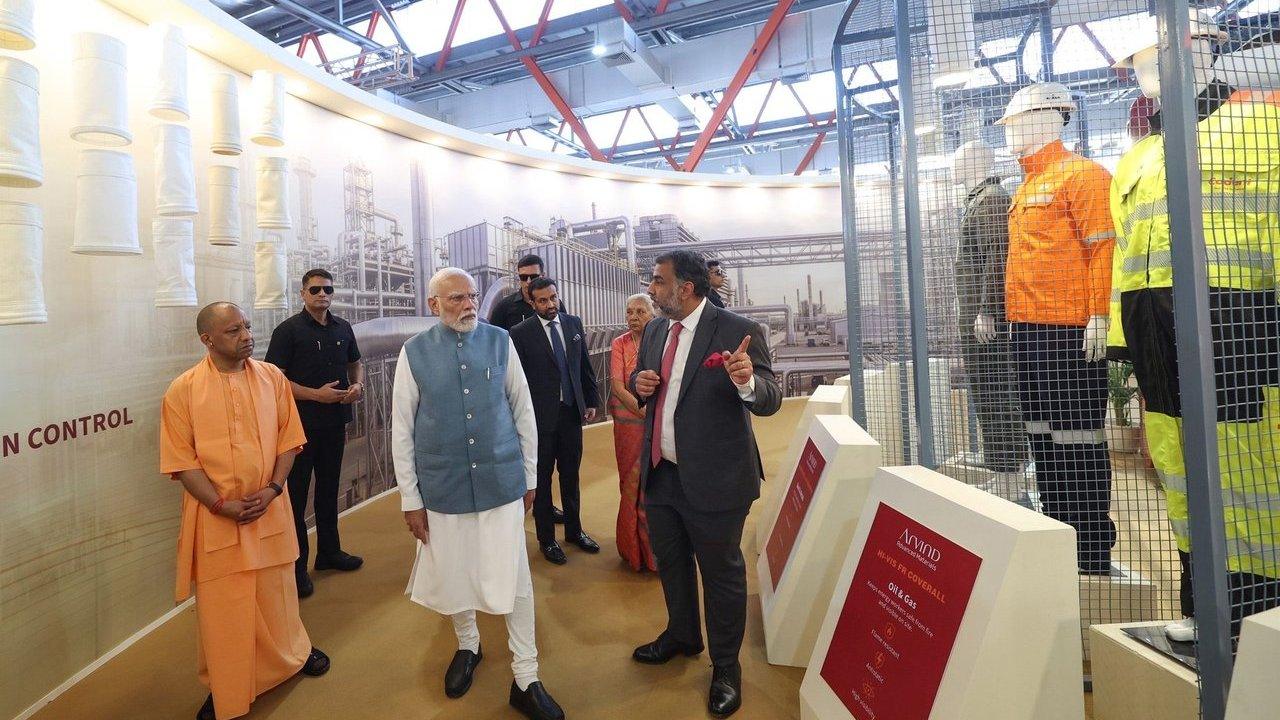 Narendra Modi and Yogi Adityanath visit an industrial exhibition with protective clothing displays.