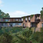 Modern two-story home with glass walls, wood cladding and greenery amid dense trees.