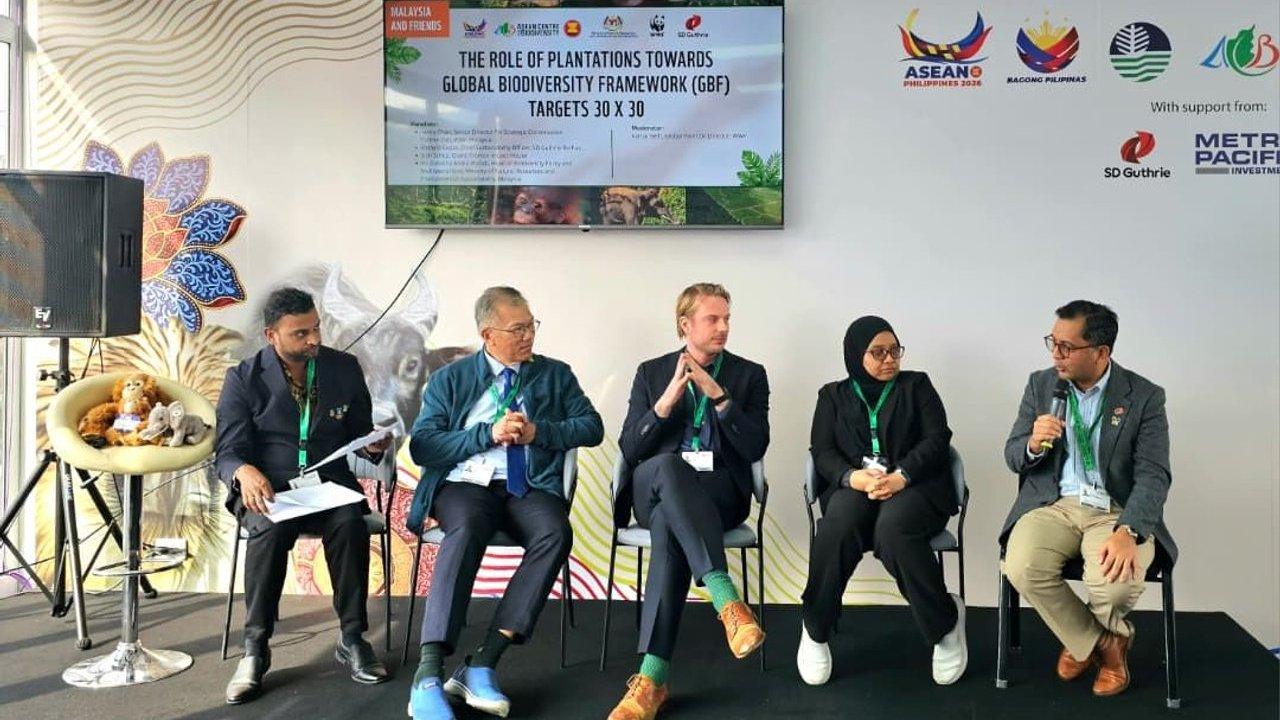 Five panelists discuss plantation biodiversity targets beneath a presentation screen.