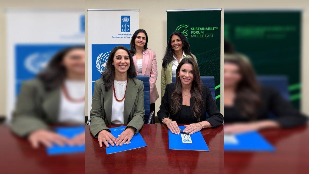 Four women at a table with UNDP folders, flanked by UNDP and Sustainability Forum Middle East banners.